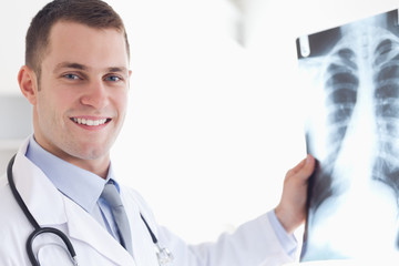 Wall Mural - Smiling doctor showing x-ray to patient