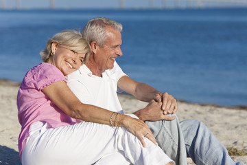 Wall Mural - Happy Romantic Senior Couple Sitting Together on Beach