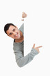 © WavebreakmediaMicro - Smiling young male pointing around the corner