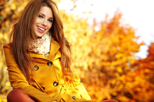 Portrait Of An Autumn Woman Lying Over Leaves And Smiling