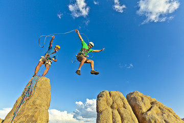 Rock climbing team reaching the summit.