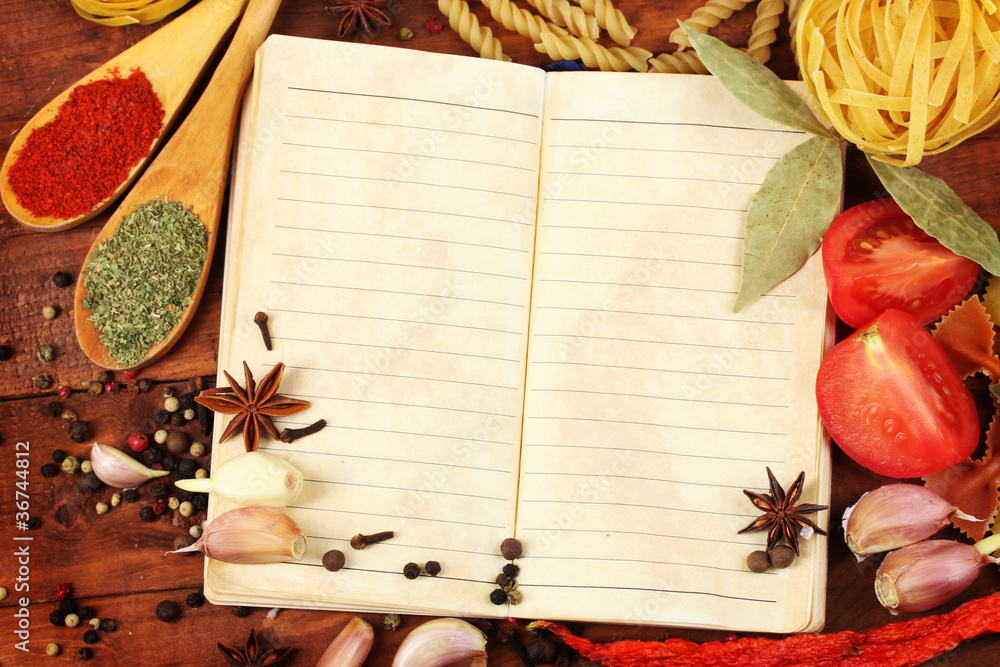 notebook for recipes and spices on wooden table
