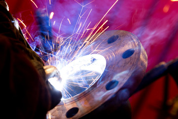 Wall Mural - factory worker welding metal and sparks spreading