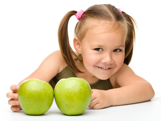 Little girl with two green apples