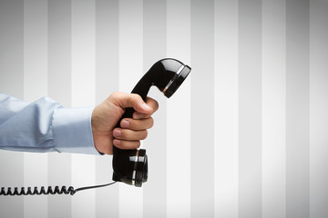 Human hand holding vintage telephone with copy space