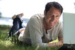© auremar - Man smiling working on the grass