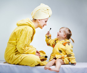 Daughter and mother putting makeup after bathroom