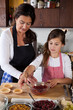 © Simone van den Berg - Mother and daughter baking at home