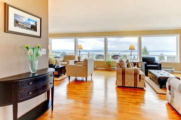 Living room with many windows and shiny wood floor.