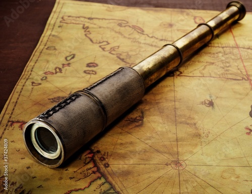 Board z aluminiowym obramowaniem Zbliżenie spyglass na starej mapie