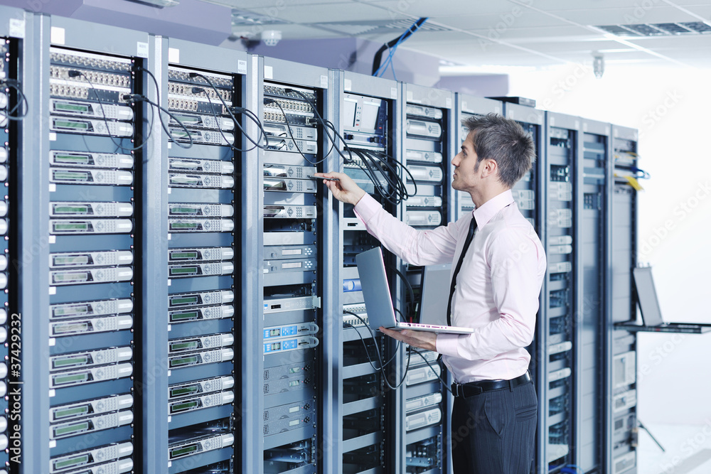 businessman with laptop in network server room - obrazy, fototapety, plakaty 