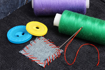 rhomb-shaped patch on jeans with threads and buttons closeup