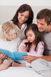 © WavebreakmediaMicro - Portrait of a family reading a book