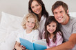 © WavebreakmediaMicro - Happy family reading a book