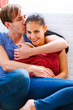 © Alliance - Portrait of a young couple sitting on divan
