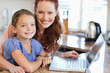 © WavebreakmediaMicro - Mother and daughter with notebook in the kitchen