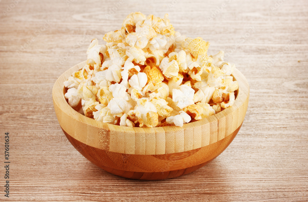 popcorn in wooden bowl on wooden table