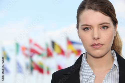 Fotomural Woman standing outside flags in background