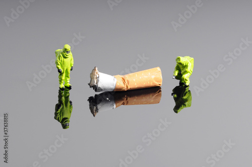 Fotografie, Obraz Tiny firefightes figures in hazmat suits examine cigarette butt
