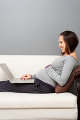 Wall Mural - smiley pregnant woman with laptop