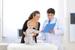 © Alliance - Baby touching card while pediatrician talking with mother