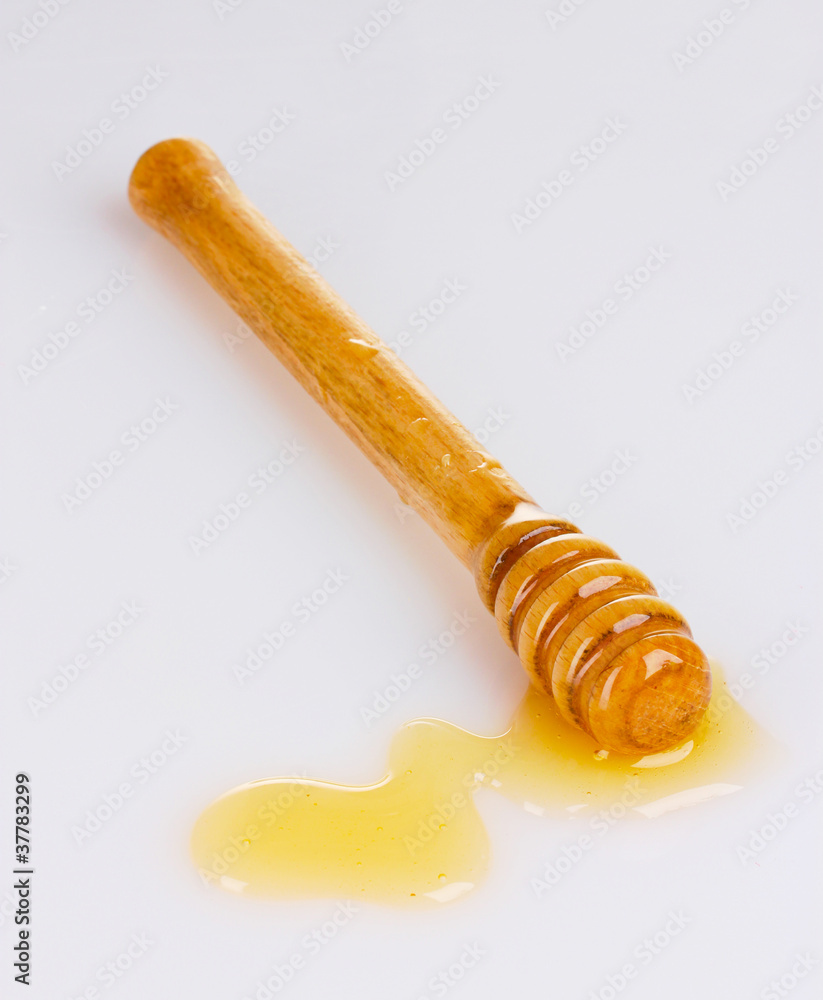 Wooden honey  dipper with honey isolated on white
