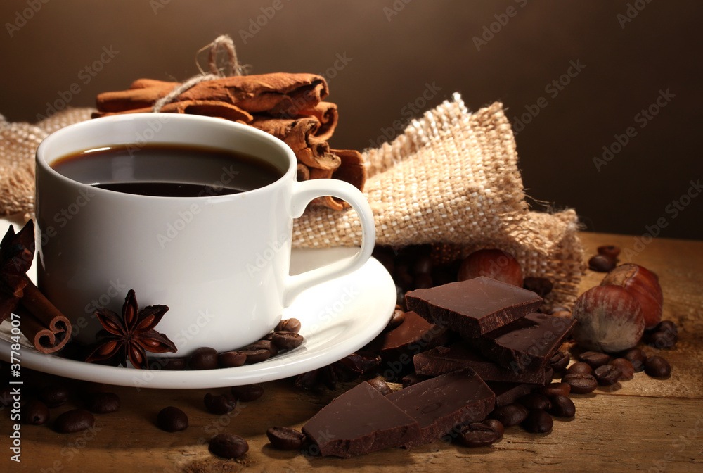 coffee cup and beans, cinnamon sticks, nuts and chocolate