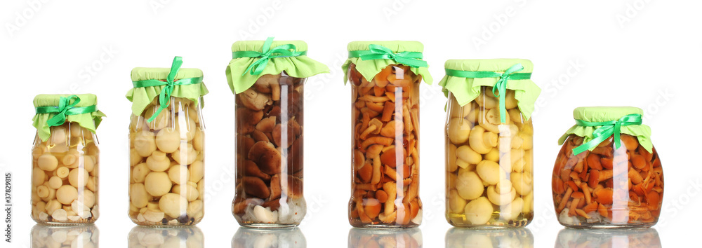 delicious marinated mushrooms in the glass jars isolated