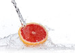 Grapefruit slice in water splash, isolated on white background