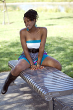 Attractive Young Black Woman Straddling Park Bench