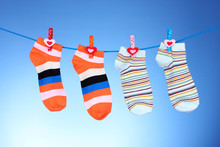 Bright Striped Socks On Line On Blue Background
