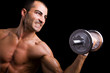 © cristovao31 - Young man lifting weights against black background