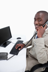 Wall Mural - Side view of a male secretary answering the phone while using a