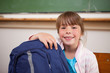 © WavebreakmediaMicro - Smiling schoolgirl posing with a bag