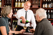 © CandyBox Images - Wine bar senior couple barman pour glass