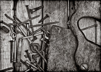 Grunge rusty saw and nails over a wooden boards