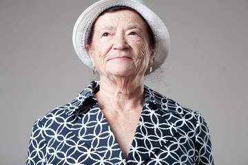 Wall Mural - Happy older lady posing on gray background.