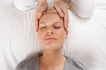 Woman having Shiatsu massage to head