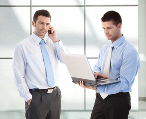 Canvas Print - Young businessmen in office lobby