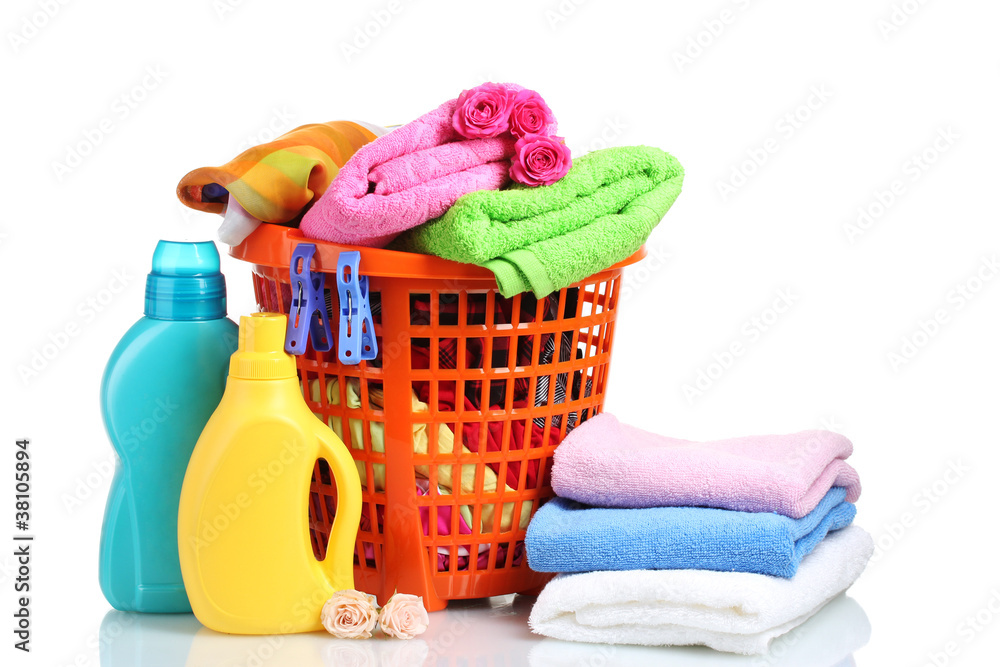Clothes with detergent in orange plastic basket isolated