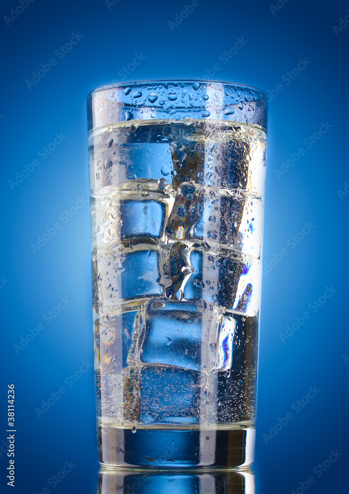 glass of water with ice on blue background