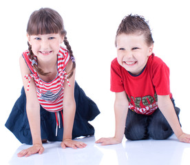 Cute blue-eyed boy and girl posing in the studio