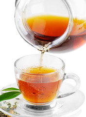 Wall Mural - Tea being poured into tea cup isolated on a white background