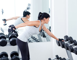 Wall Mural - woman with weight training equipment on sport gym