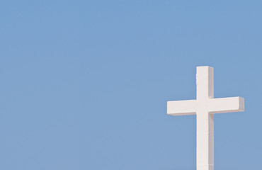 White Christian cross on blue sky