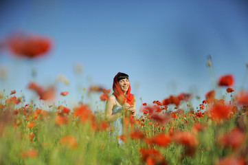 Sticker - Smiling girl in a red cloth among poppies