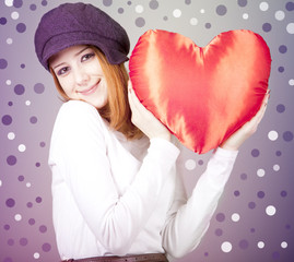 Wall Mural - beautiful red-haired girl in cap with toy heart.