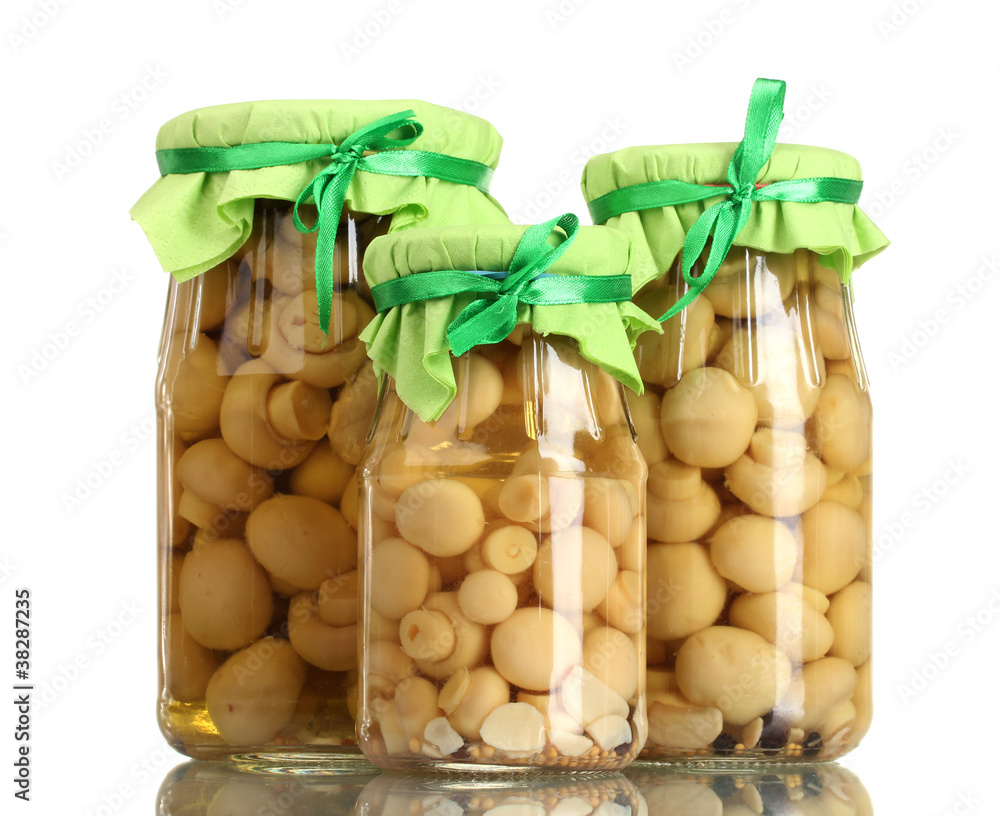 delicious marinated mushrooms in the glass jars isolated