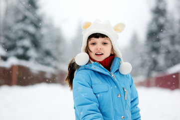 Wall Mural - Cute toddler girl in snowsuit posing outdoors