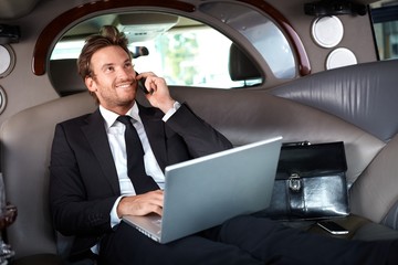 Sticker - Smiling businessman in luxury car working